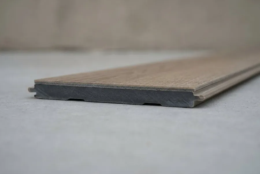 The edge of a luxury vinyl plank showing the solid core and click-lock profile